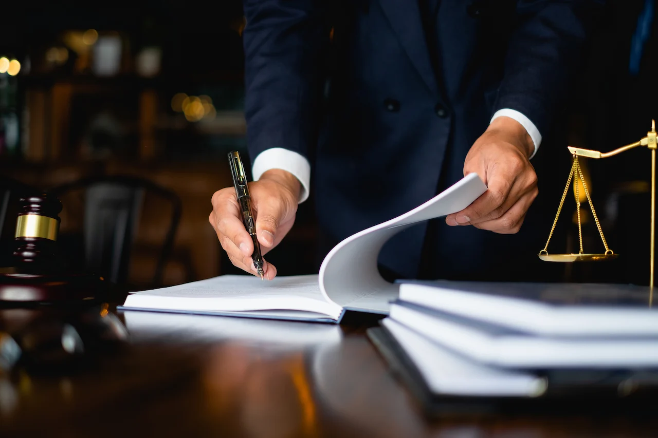 Picture of a North Carolina litigation attorney signing papers in his law office